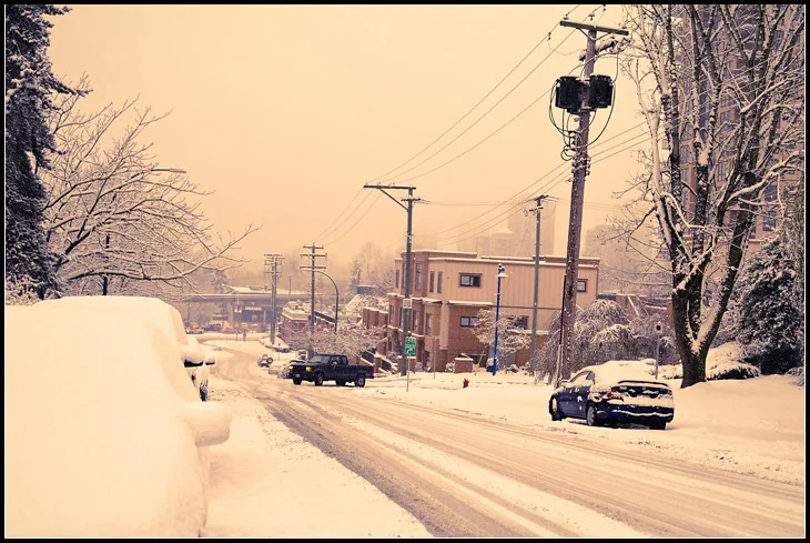 Snow-covered Coquitlam street and parked vehicles in a 2010 photograph